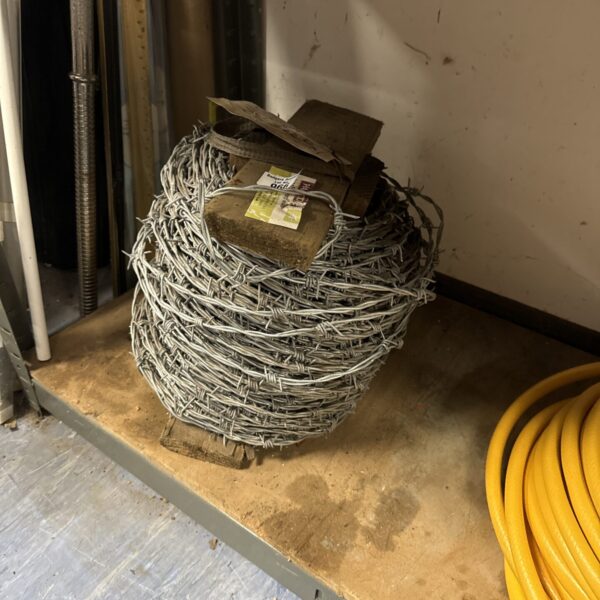 Galvanized barbed wire roll for fencing and security applications.