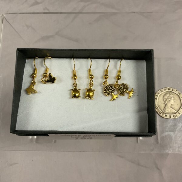 Close-up of vintage silver gilt animal earrings, including a frog.