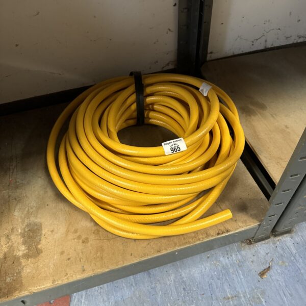 Yellow garden hosepipe coiled for storage, ideal for watering.