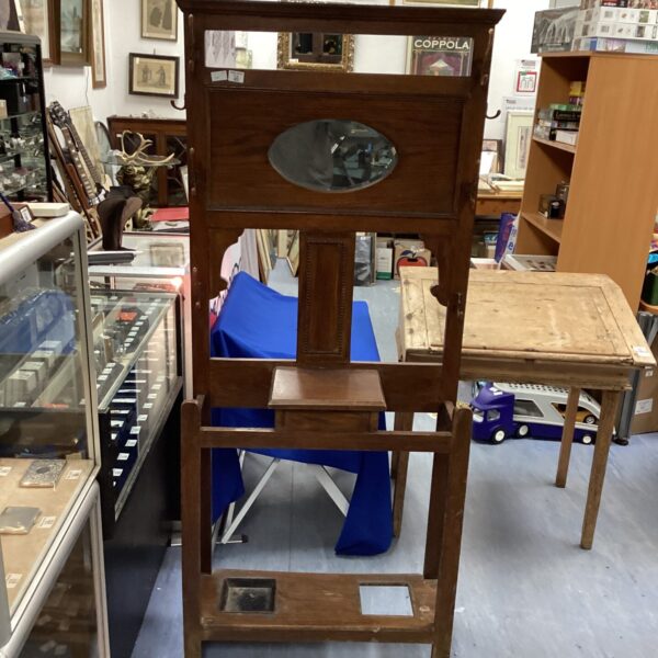 Antique mahogany hall stand with mirror and coat hooks.