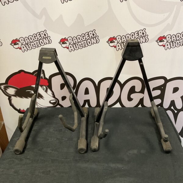 Two metal guitar stands for instruments, showing signs of use.