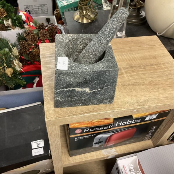 Dark grey granite pestle and mortar for grinding spices.