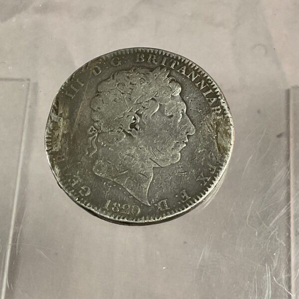 Antique 1820 George III silver crown coin obverse view.