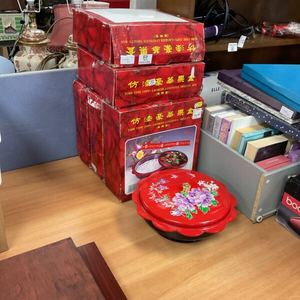 Five vintage red lacquer sweets boxes stacked together.
