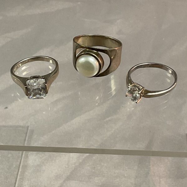 Lot of three silver stone set rings in varying styles.