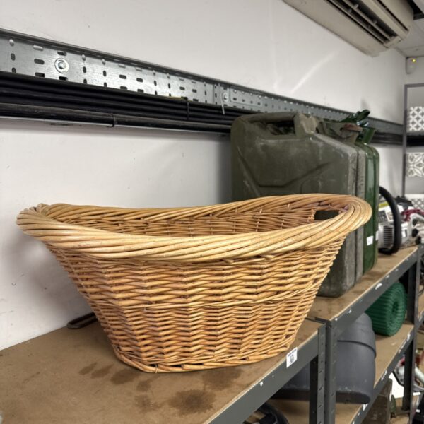 Vintage wicker laundry basket with open weave design.