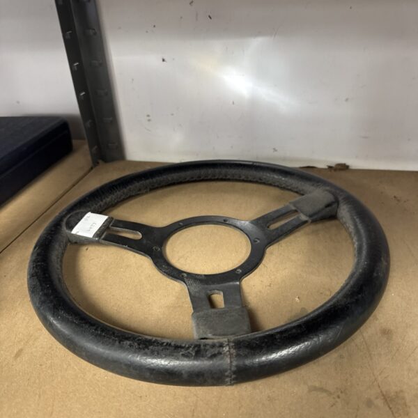 Dark vintage steering wheel for classic car restoration.