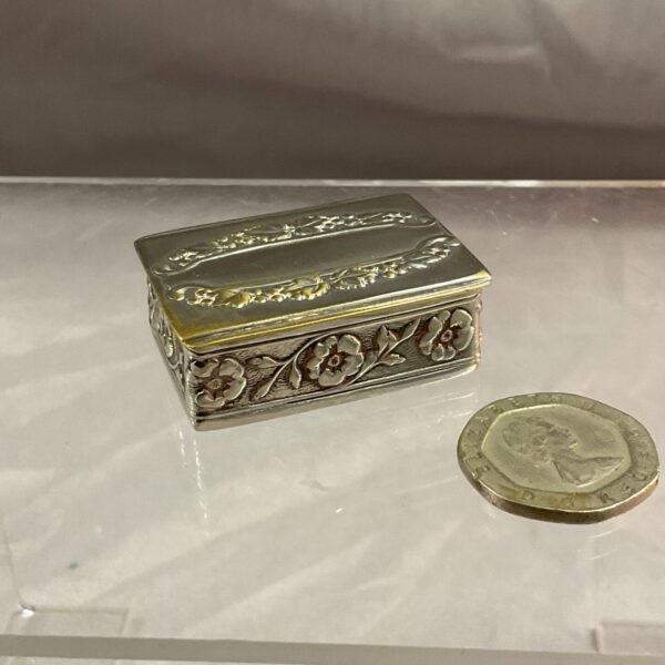 Antique silverplate snuff box with floral engraving.
