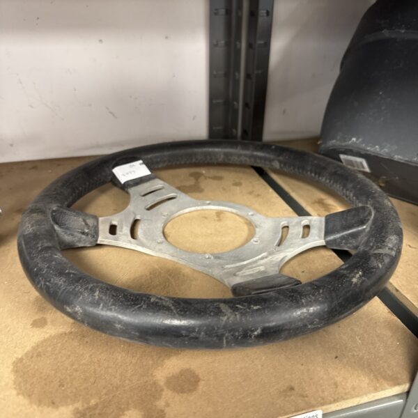 Vintage steering wheel from a classic car, showing wear.