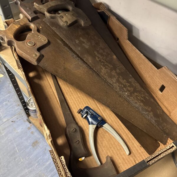 Vintage hand saws and crimping tool in a tray.
