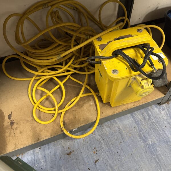 Yellow 110v transformer block with coiled extension lead.
