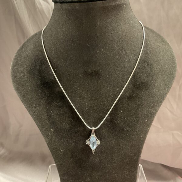 Silver necklace with a blue stone star pendant.