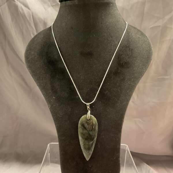 Silver necklace with green grey stone pendant on white background.