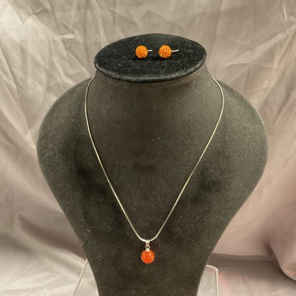 Vibrant orange ball necklace and matching earrings set on display.