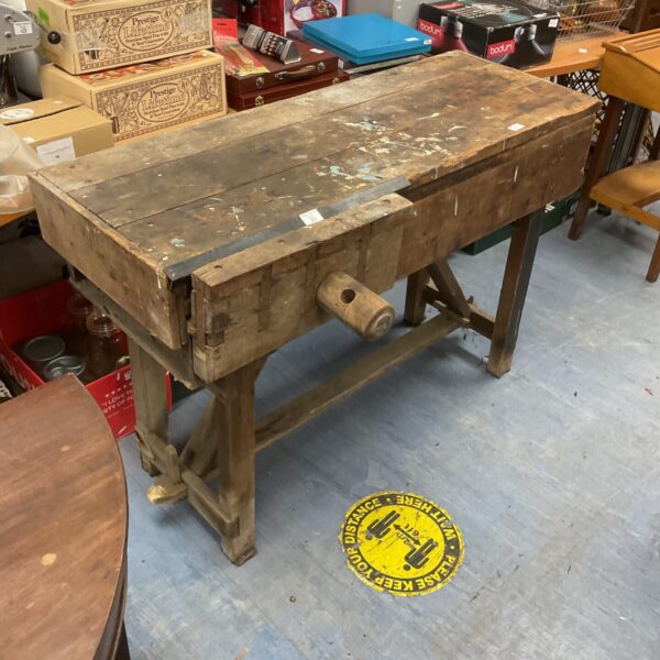 Vintage wooden workbench with signs of wear and use.