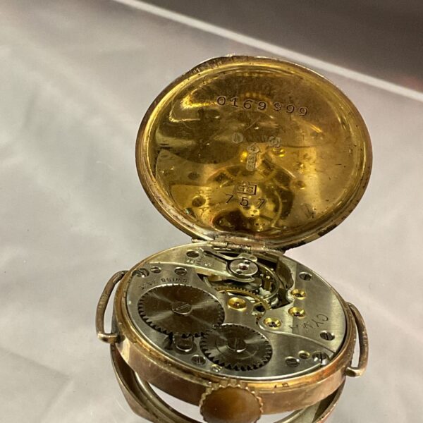 Open case of a vintage Cyma 9ct gold pocket watch.