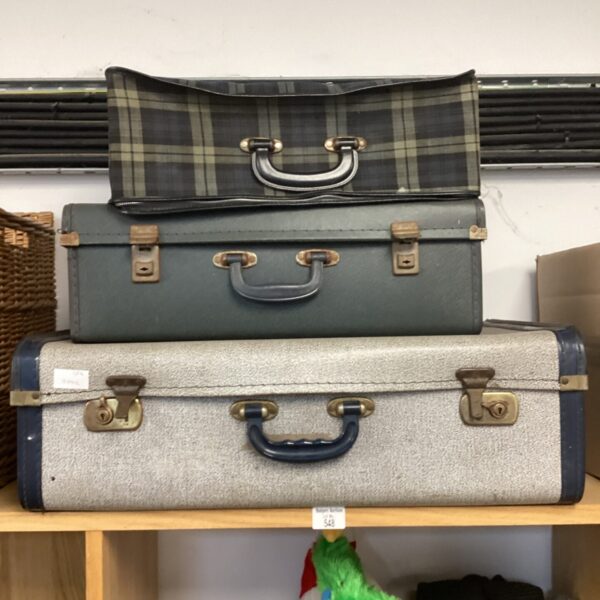 Lot of three vintage suitcases with patterned and textured exteriors.