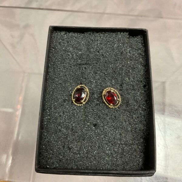 Close-up of 9ct gold garnet earrings with butterfly backs.