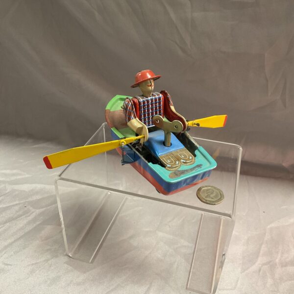 Vintage tinplate clockwork rowing boat with colourful details.