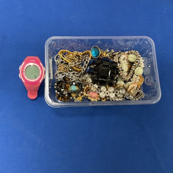 Mixed lot of costume jewellery and a Crivit watch on display.