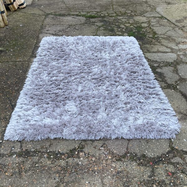 Soft light gray fleece rug for living room comfort.