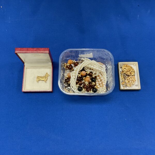 Vintage costume jewellery lot with bead necklaces and brooches.