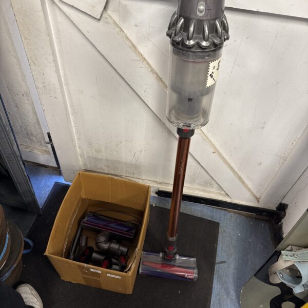 Front view of a Dyson V10 cordless vacuum cleaner with accessories.
