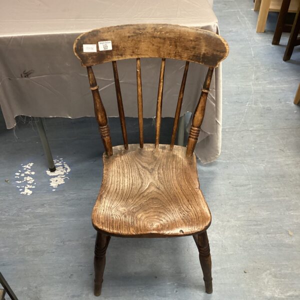Antique stick back chair with a shaped seat and wooden construction.