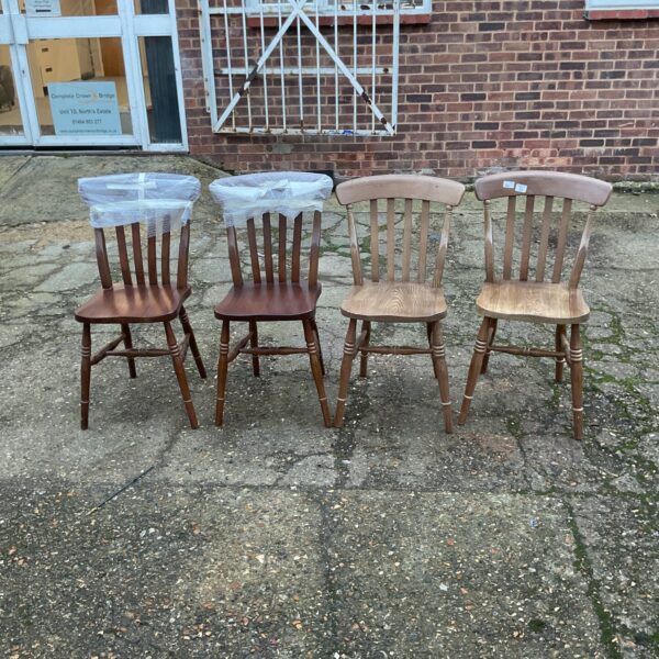 Four vintage stick back dining chairs with wood frames.