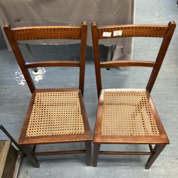 Pair of vintage canework chairs with woven seats and backs.