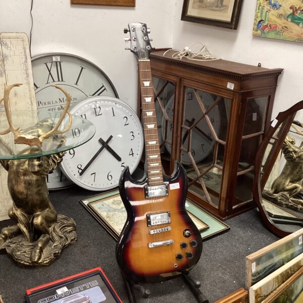 Sunburst electric guitar displayed in an auction setting.