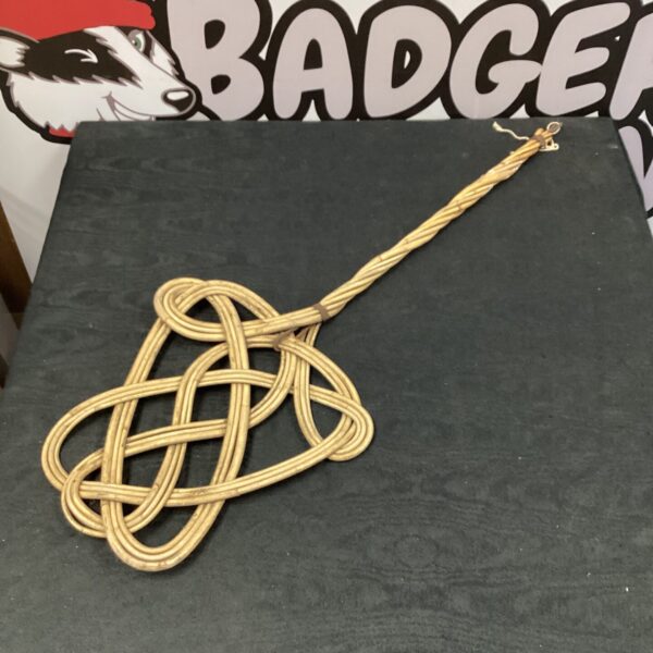 Vintage carpet beater with woven handle and paddle.