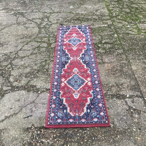 Red runner rug with oriental pattern in a hallway setting.