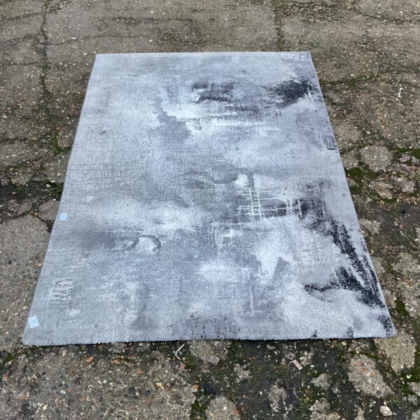 Close-up of a grey area rug with visible texture.