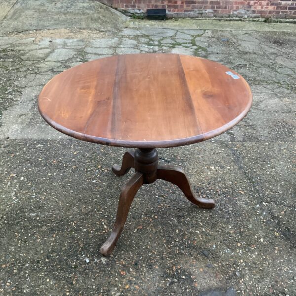 Antique mahogany folding dining table with circular top.