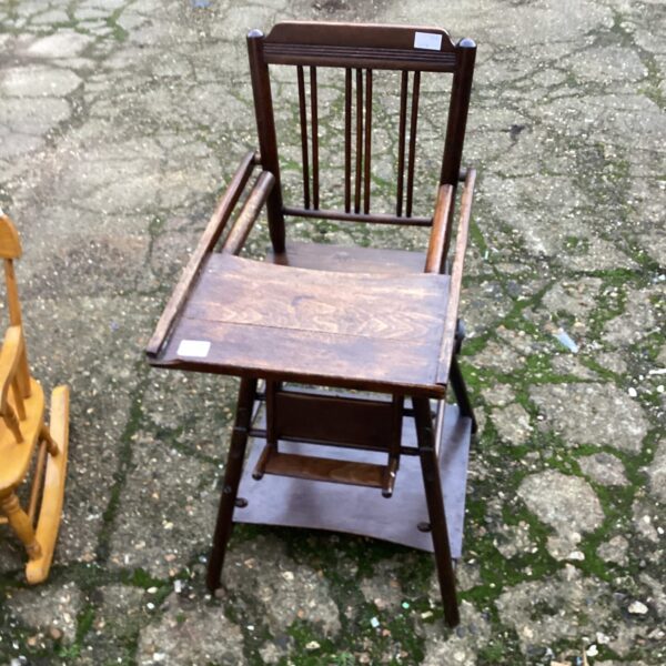 Vintage wooden child's high chair with slatted design.