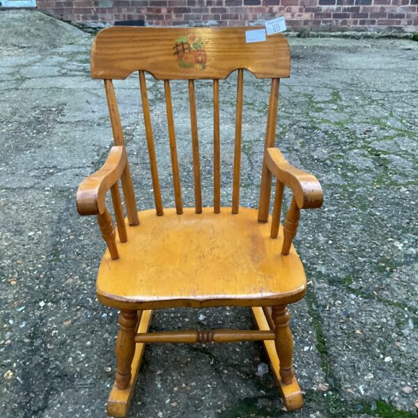 Vintage pine childs rocking chair with spindles and curved rockers.
