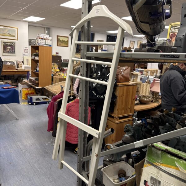 Vintage tiered metal clothes rack for garment display.