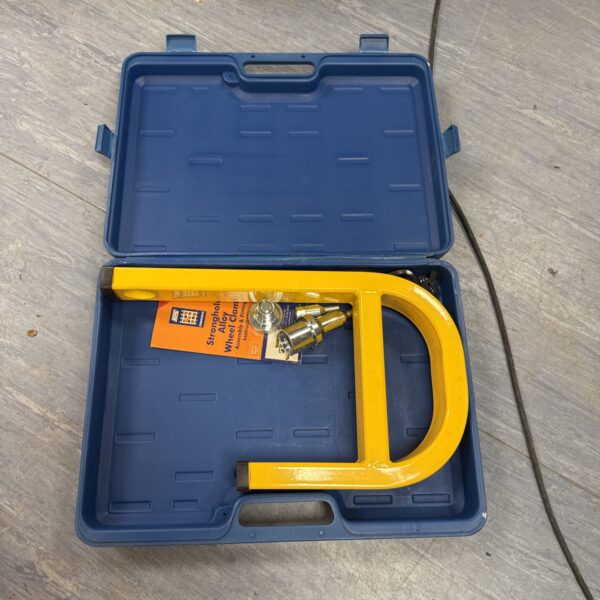 Closed carrying case containing an alloy wheel clamp for car security.