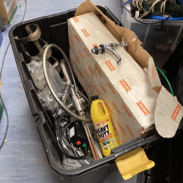 Assorted plumbing fixtures and taps in a storage container.