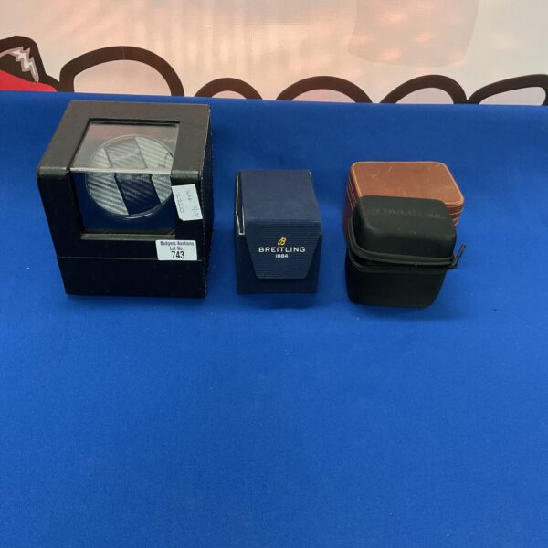 Selection of empty watch boxes and an automatic watch winder for collectors.