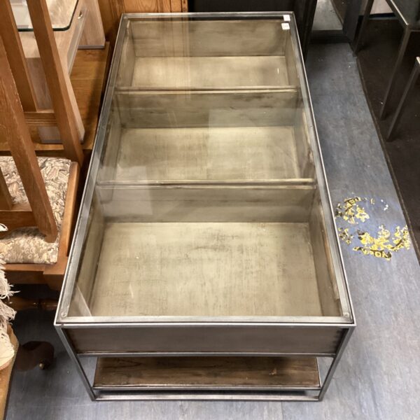 Modern chrome coffee table with glass top and three drawers.