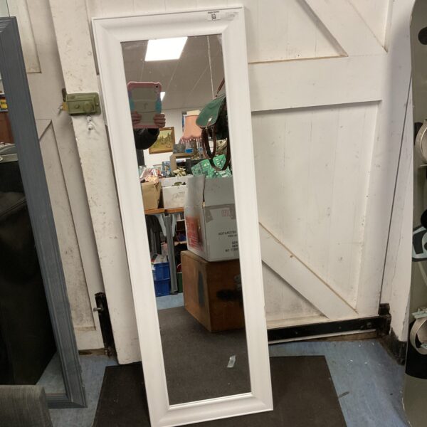 Full length white framed mirror for home decor.