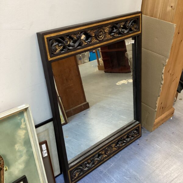 Large ornate gold and black framed mirror for wall decoration.