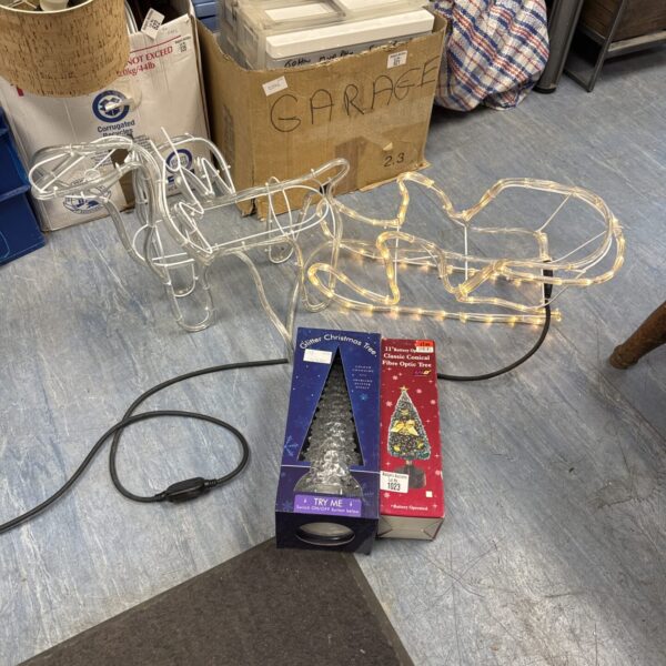 Festive Christmas light display with reindeer and sleigh needing attention.