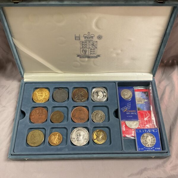 Open Royal Mint coin collection case displaying commemorative coins and medals.