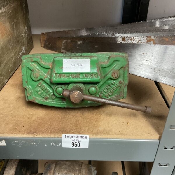 Small green vintage bench vice for workshop use.