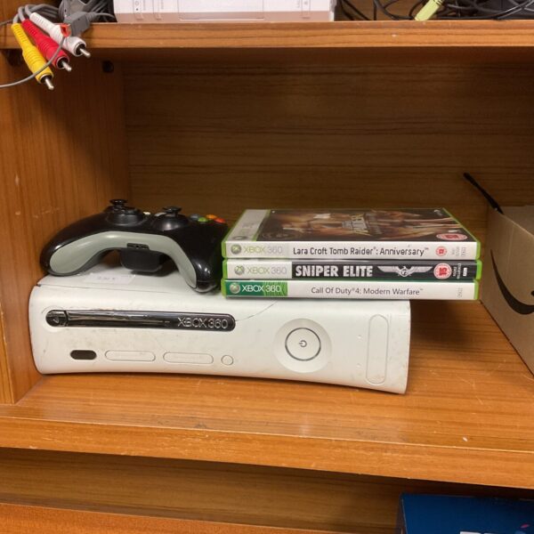 Microsoft Xbox 360 console with controller and games.