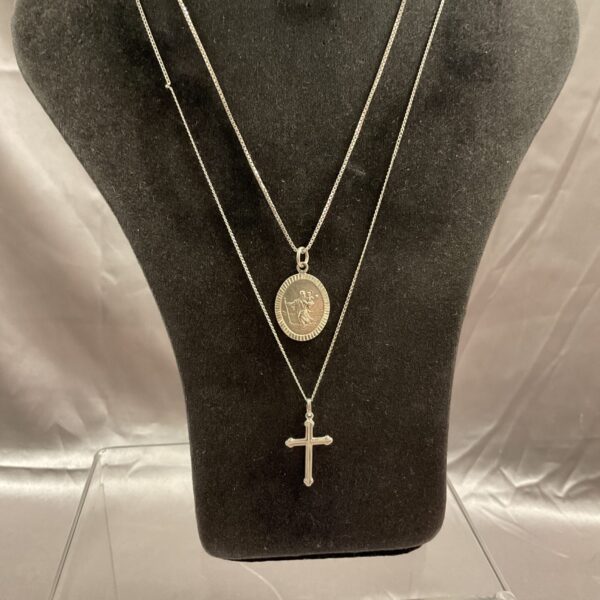Silver pendant necklaces featuring a cross and St Christopher.