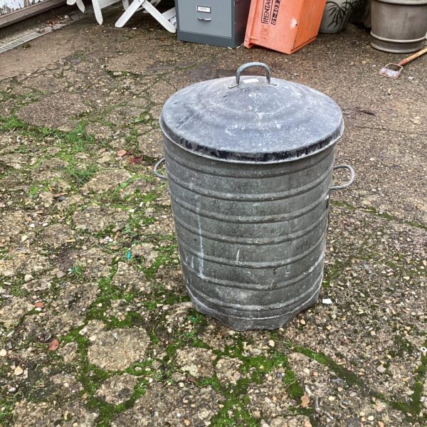 Vintage galvanised dust bin with hinged lid, showing signs of age.